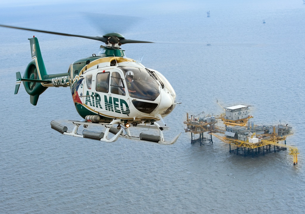 AirMed Offshore-2 Air Med helicopter flying over an oil rig offshore
