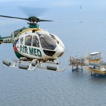 Air Med helicopter flying over an oil rig offshore